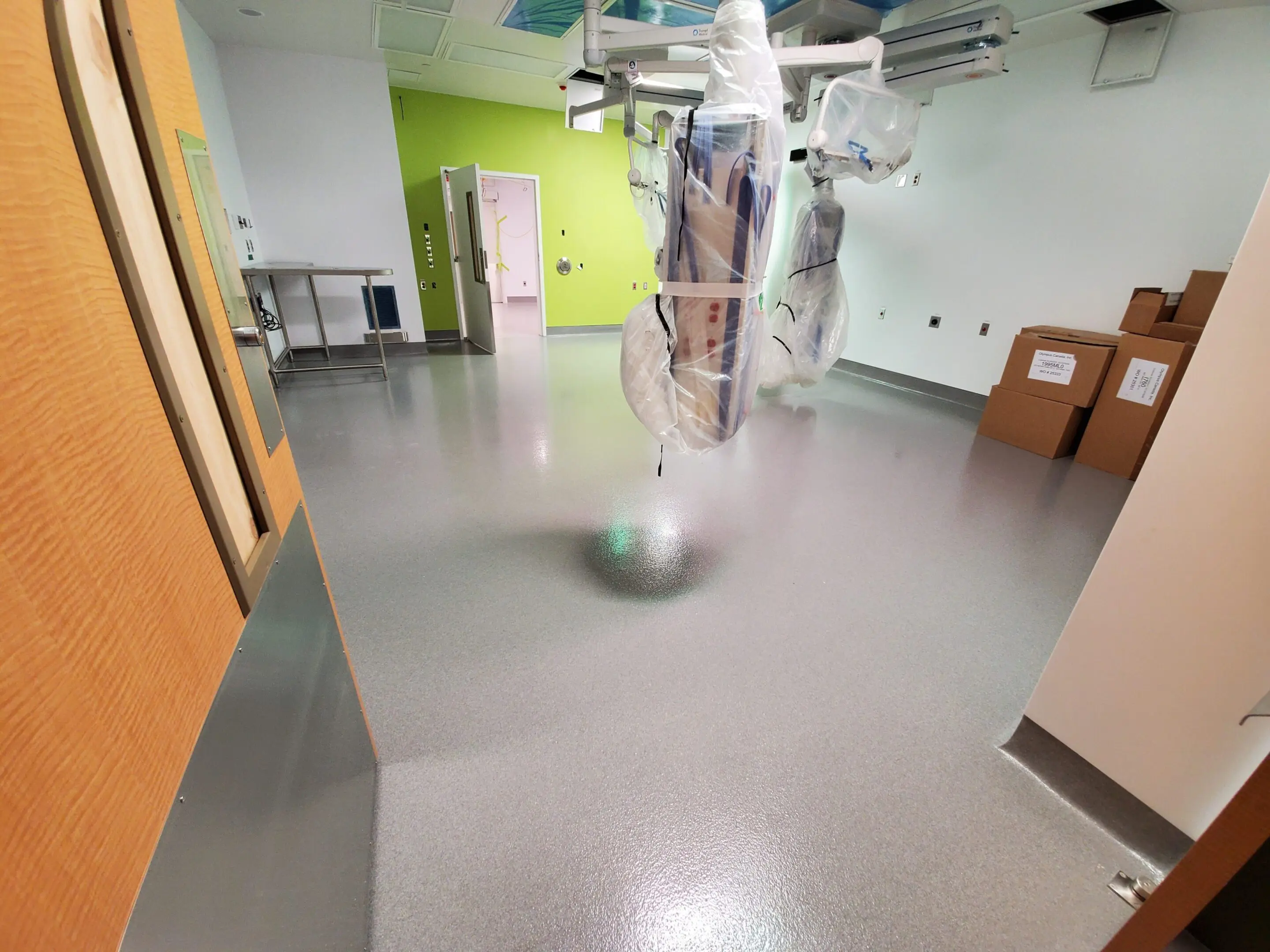 Hospital hallway with clean, shiny floor and medical equipment.