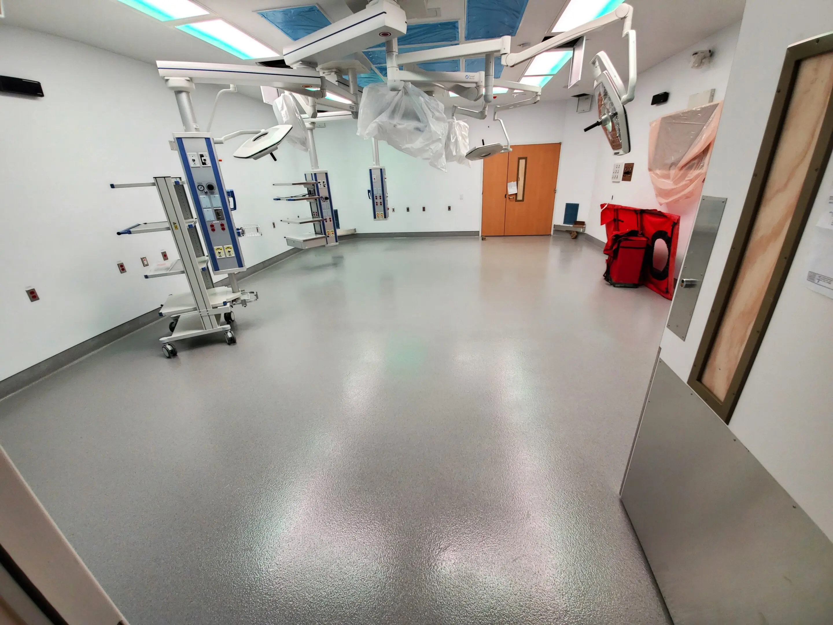 Empty medical procedure room with sterile equipment and bright lighting.