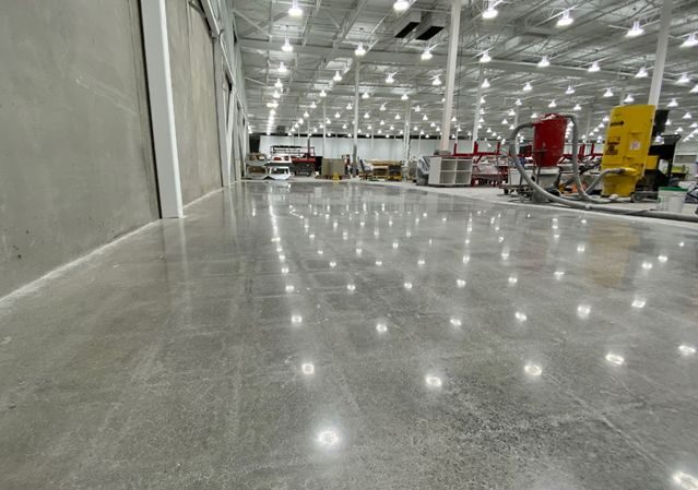 Shiny polished concrete floor in a spacious industrial warehouse.